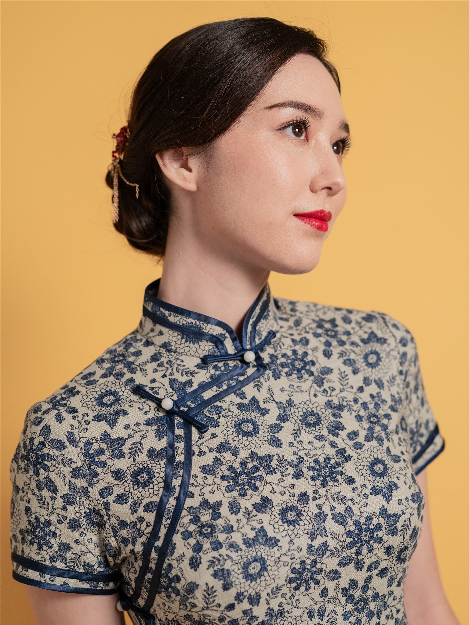 Close-up detail of a Qipao/Cheongsam dress, featuring mandarin collar and navy blue piping. 