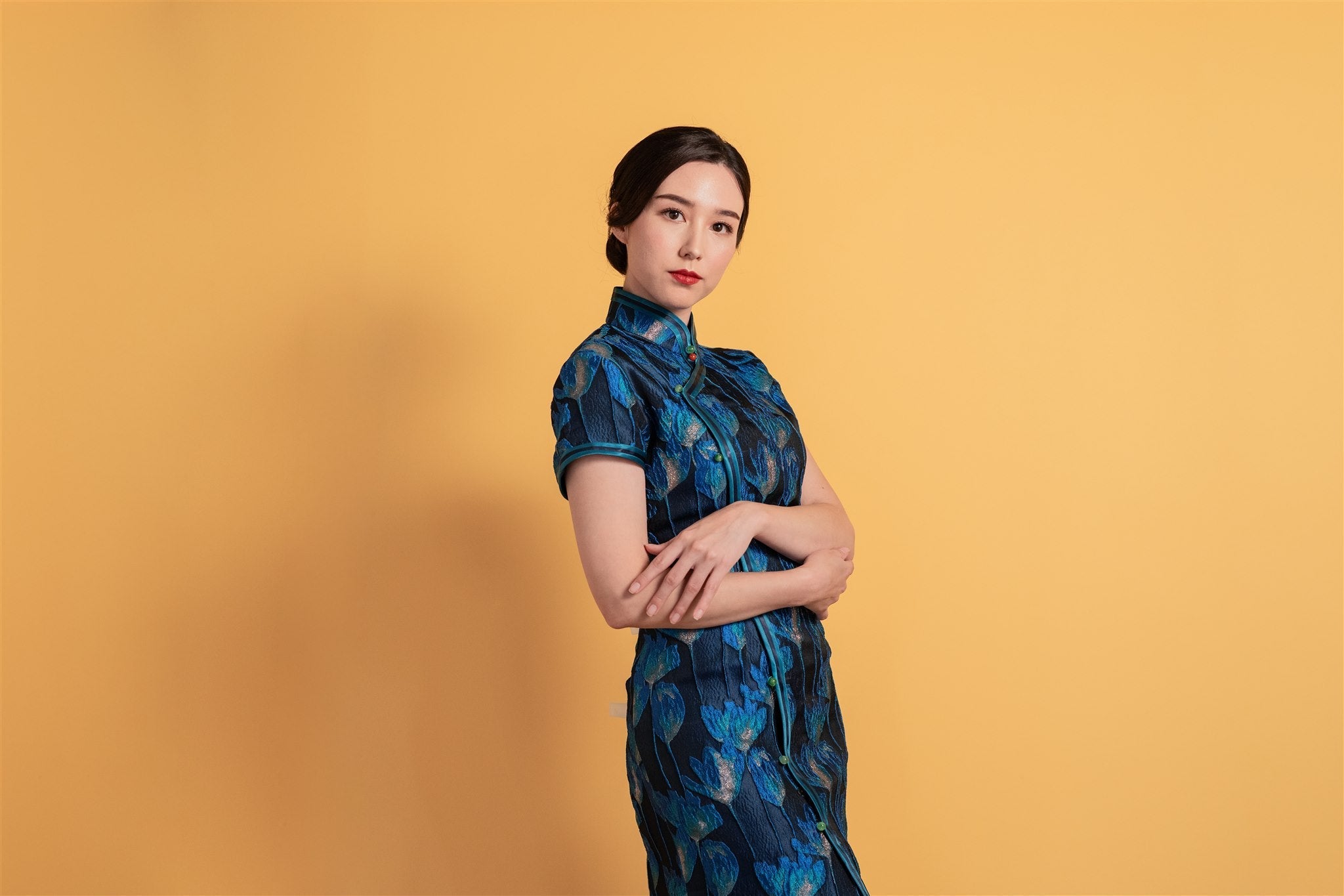 Side view of a navy blue tulip-patterned cotton Qipao featuring an A-line design, cap sleeves, and elegant green button side closure.
