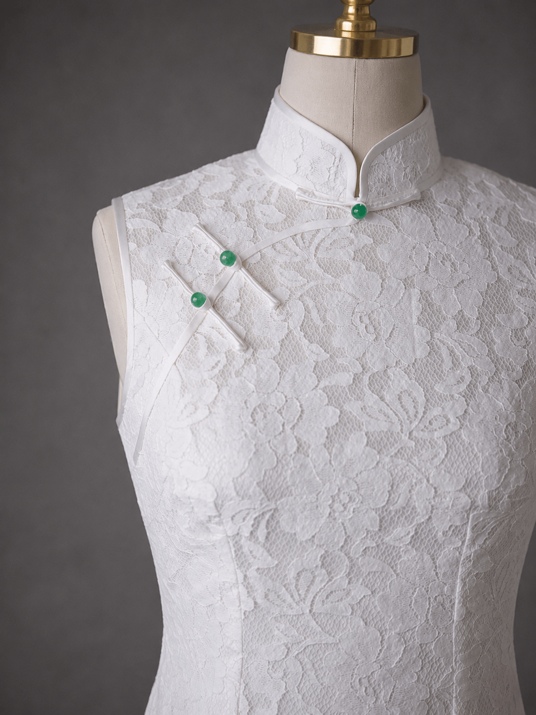 Detail of ready to wear white French Chantilly lace Qipao with jade Pankou knot closures — sleeveless wedding Qipao by JINZA Oriental Couture, Los Angeles