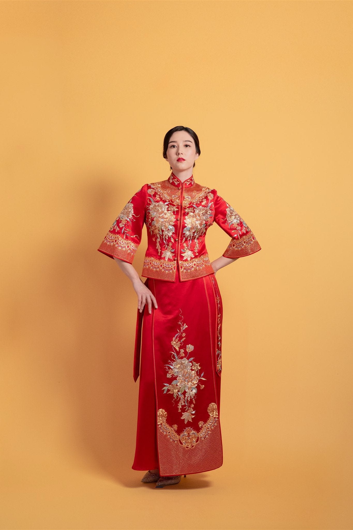 Front view of a red Chinese tea ceremony dress Xiu He Fu featuring a fitted top with peony embroidery and A-line skirt.