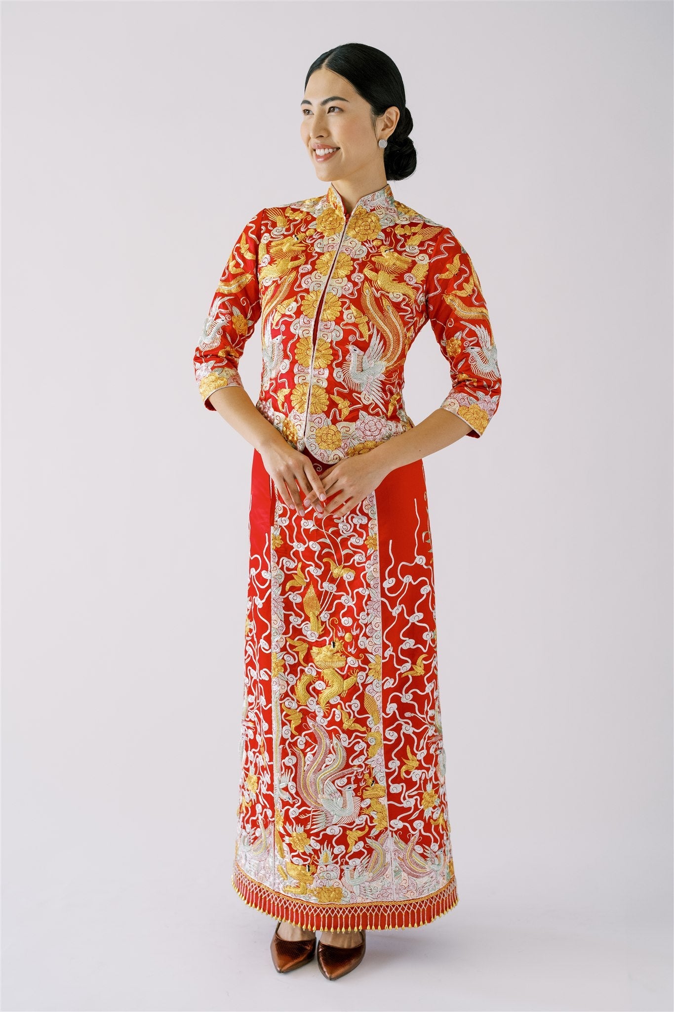 A woman wearing a red Chinese Wedding Dress Qun Kwa with dragon and phoenix embroidery