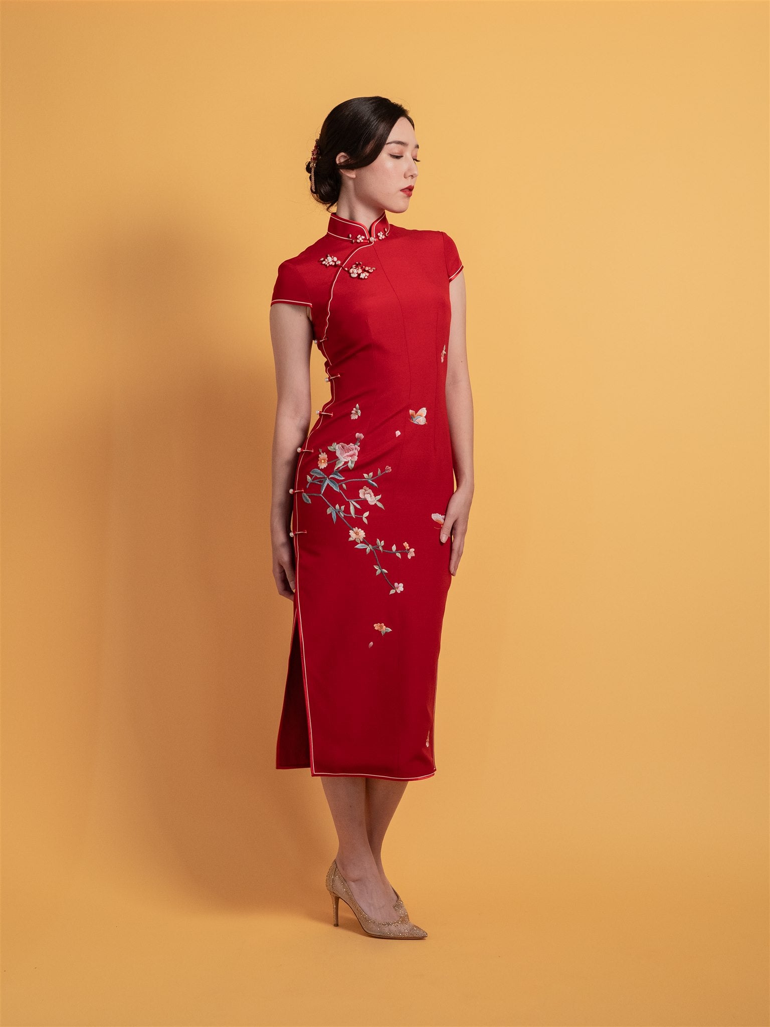 Side view of a red Japanese silk Chinese Dress featuring floral and butterfly embroidery, mid-calf length, and cap sleeves, designed for a modern tea ceremony wedding.