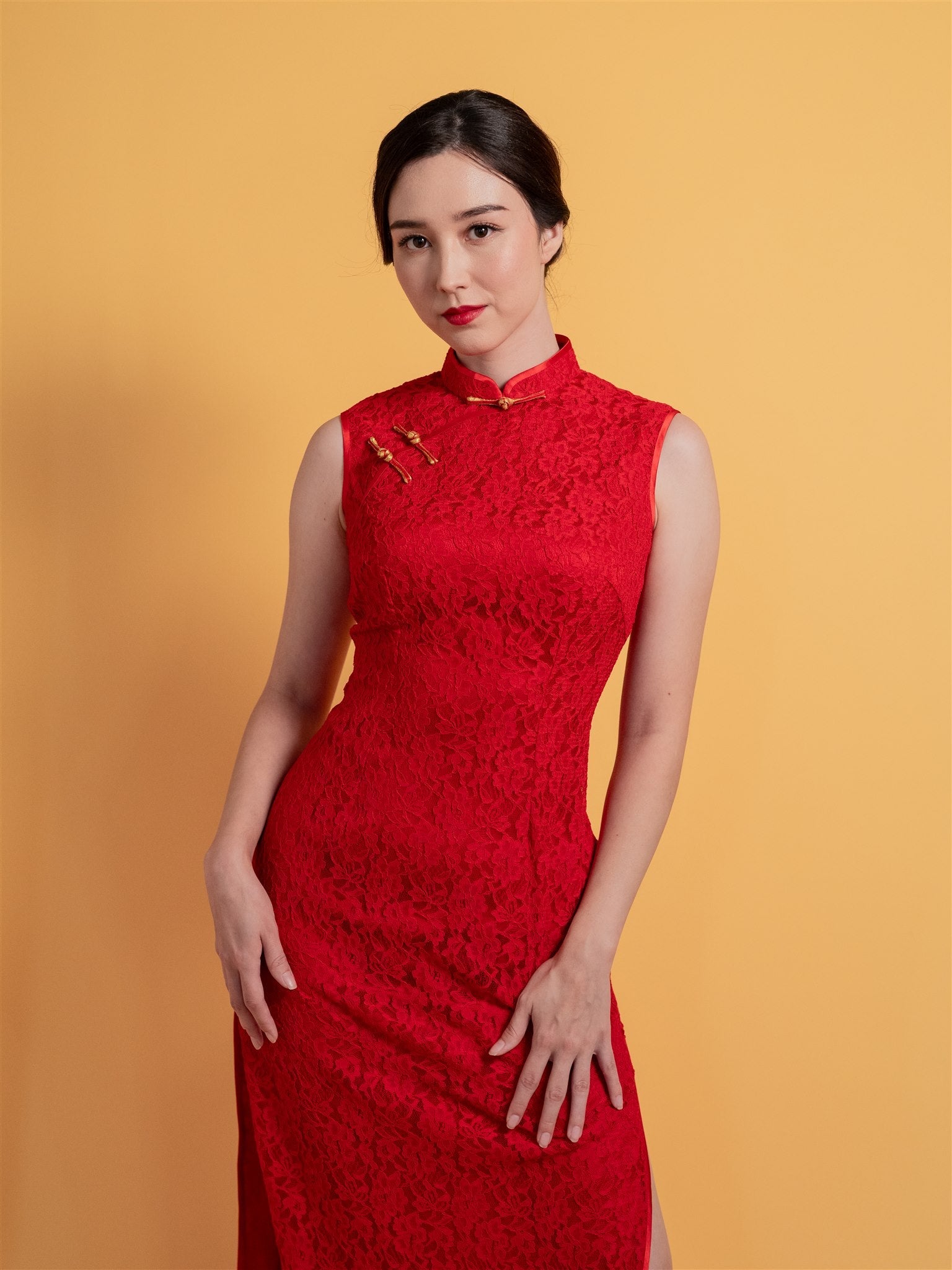 Close-up detail of the mandarin collar, gold and red Pankou knot and intricate lace design on a sleeveless red Chinese Wedding Dress, ideal for a minimalist wedding style.