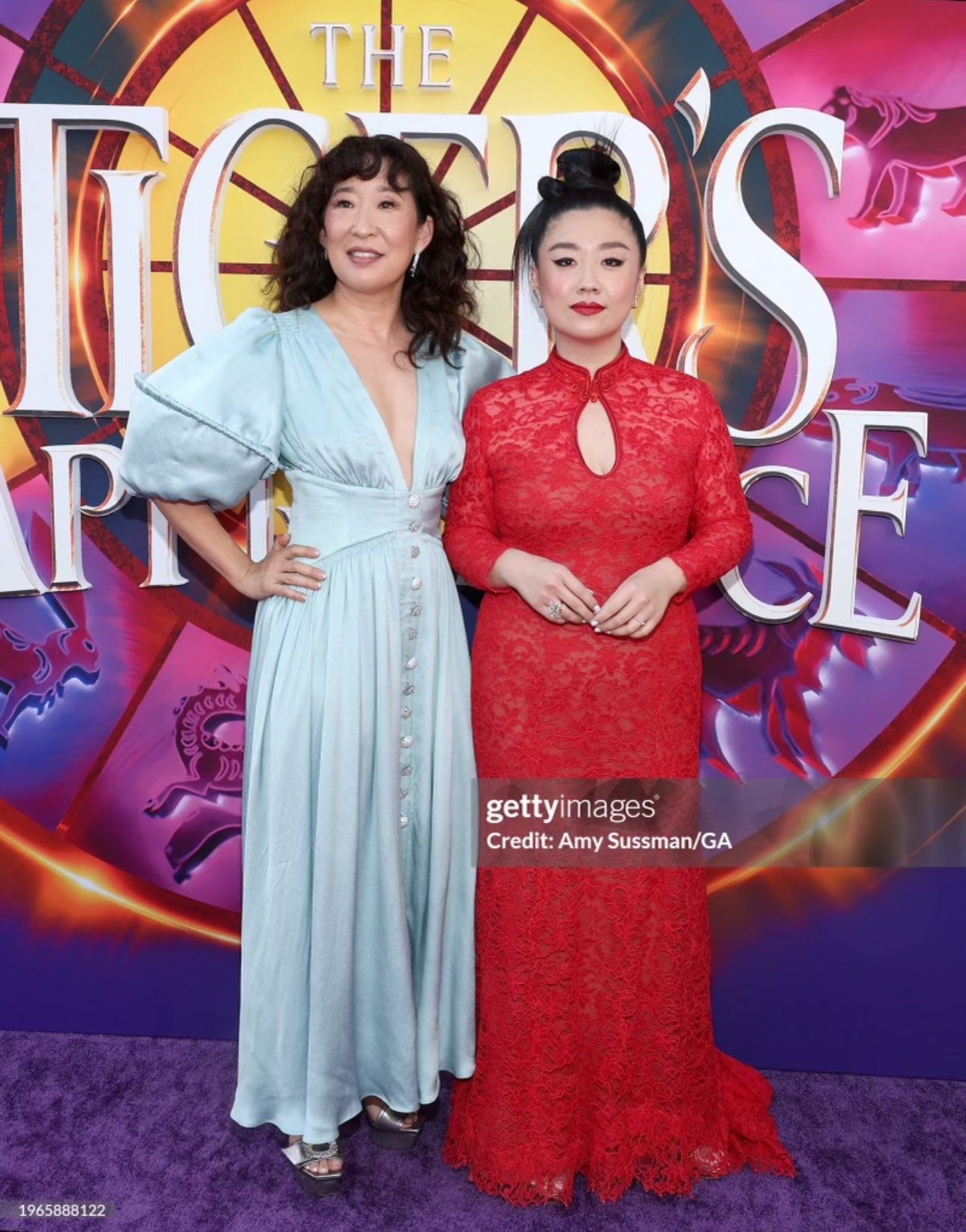 Actresses Sherry Cola and Sandra Oh at a movie premiere, with Sherry Cola wearing a red lace Qipao by JINZA Oriental Couture representing modern Chinese couture