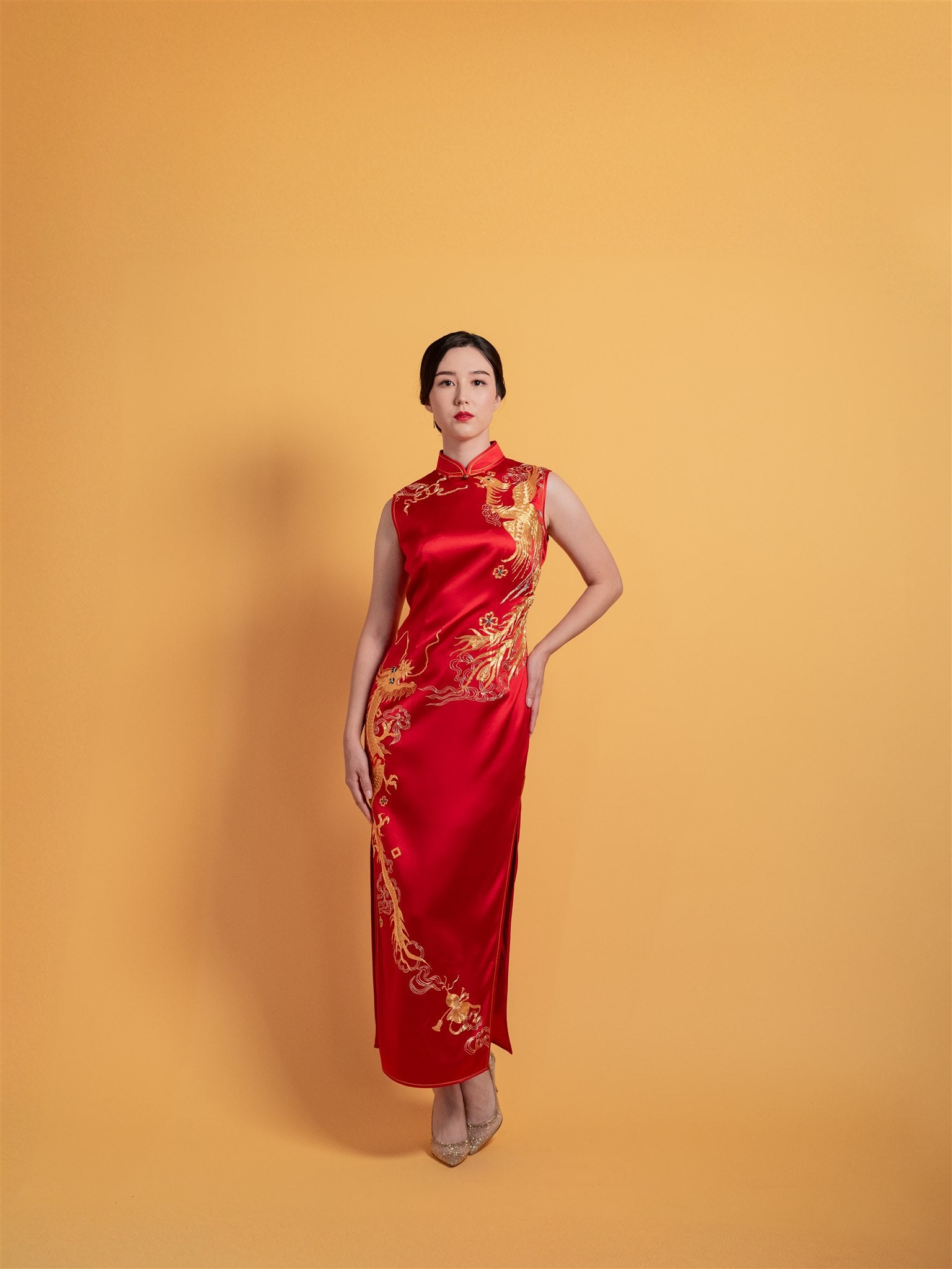 Front view of the best-selling red silk Chinese dress for weddings, sleeveless, featuring gold dragon and phoenix embroidery.