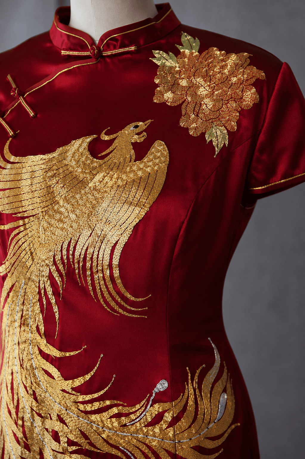 Gold phoenix and peony hand embroidery detail on red silk Qipao