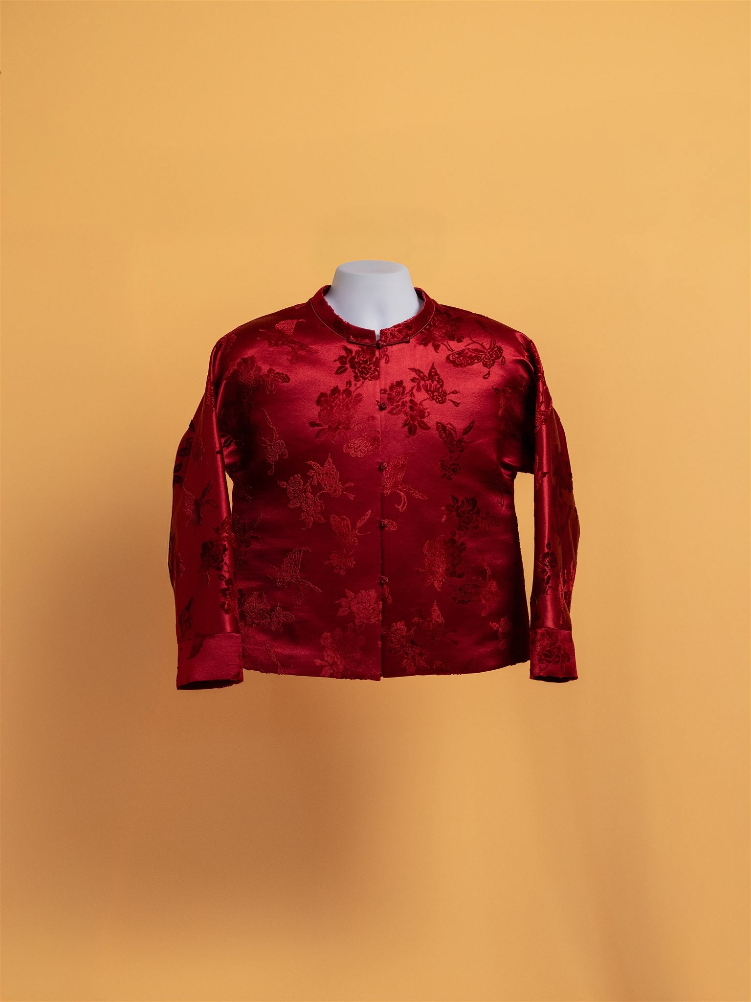 Front image of a red silk brocade with peony pattern tang suit for woman. 