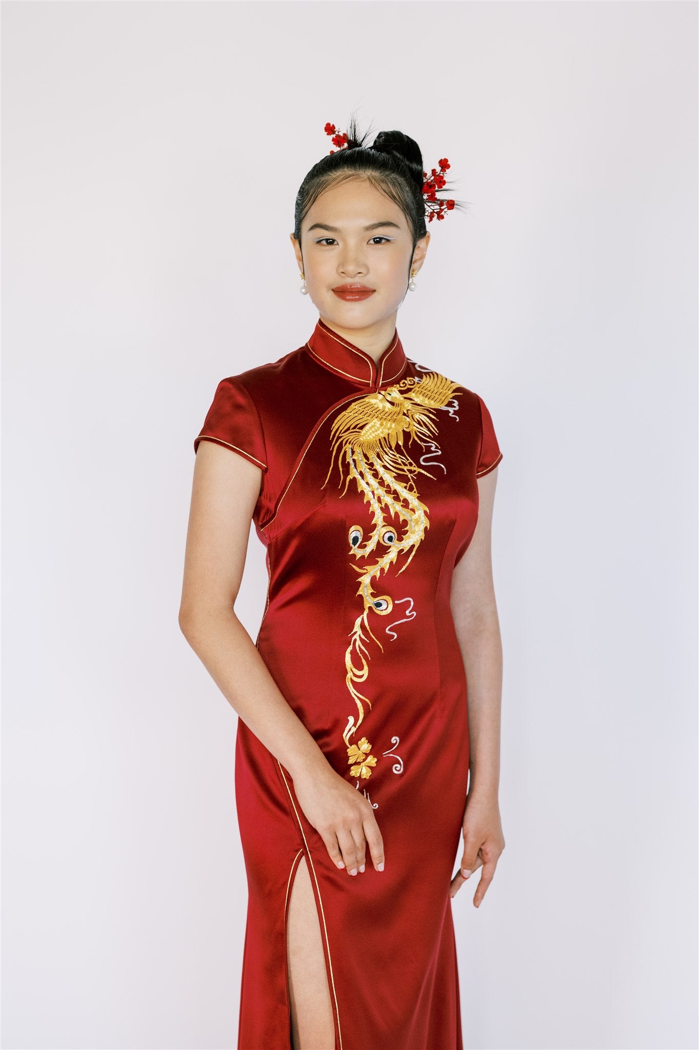 A girl wearing a wine red Chinese Wedding Dress with phoenix front slit