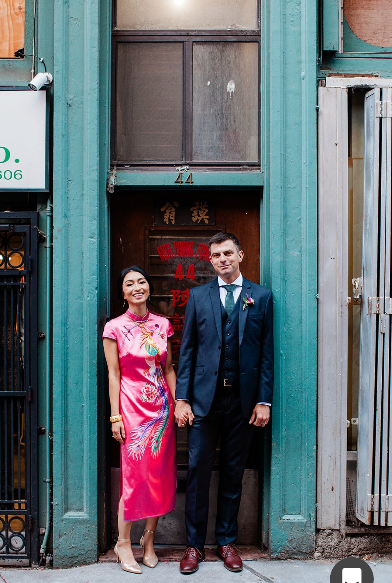 A woman wearing a red Wedding Qipao   and holding her husband's hands