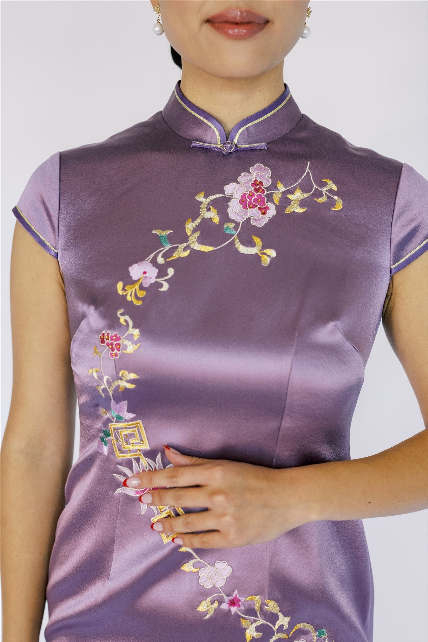 Floral embroidery details on a purple silk Qipao dress