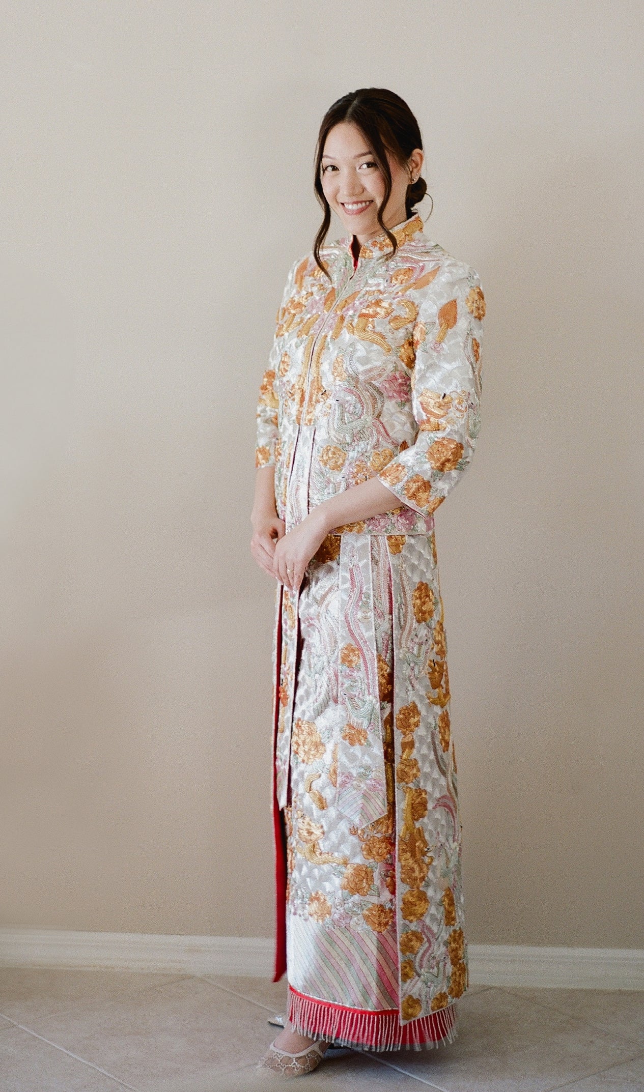 A bride wearing a Traditional Chinese Wedding Dress King Kwa with gold and silver embroidery 