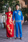 Front image of a groom wearing blue silk Tang and blue pants set, with gold dragon and moon embroidery at his tea ceremony. 