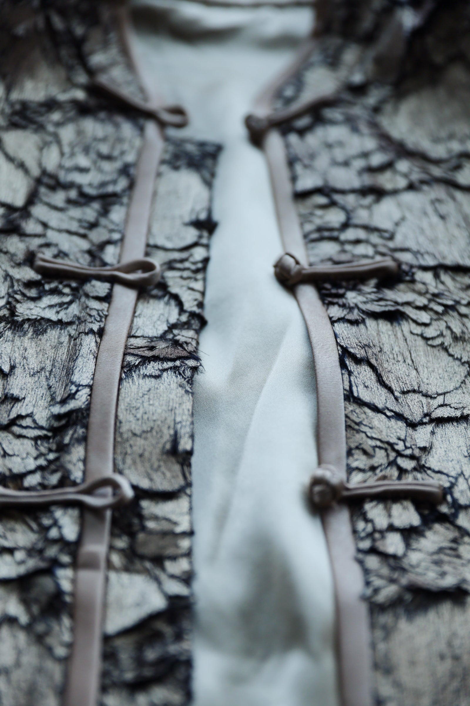 Front opening detail of Italian gold silk Tang suit jacket.