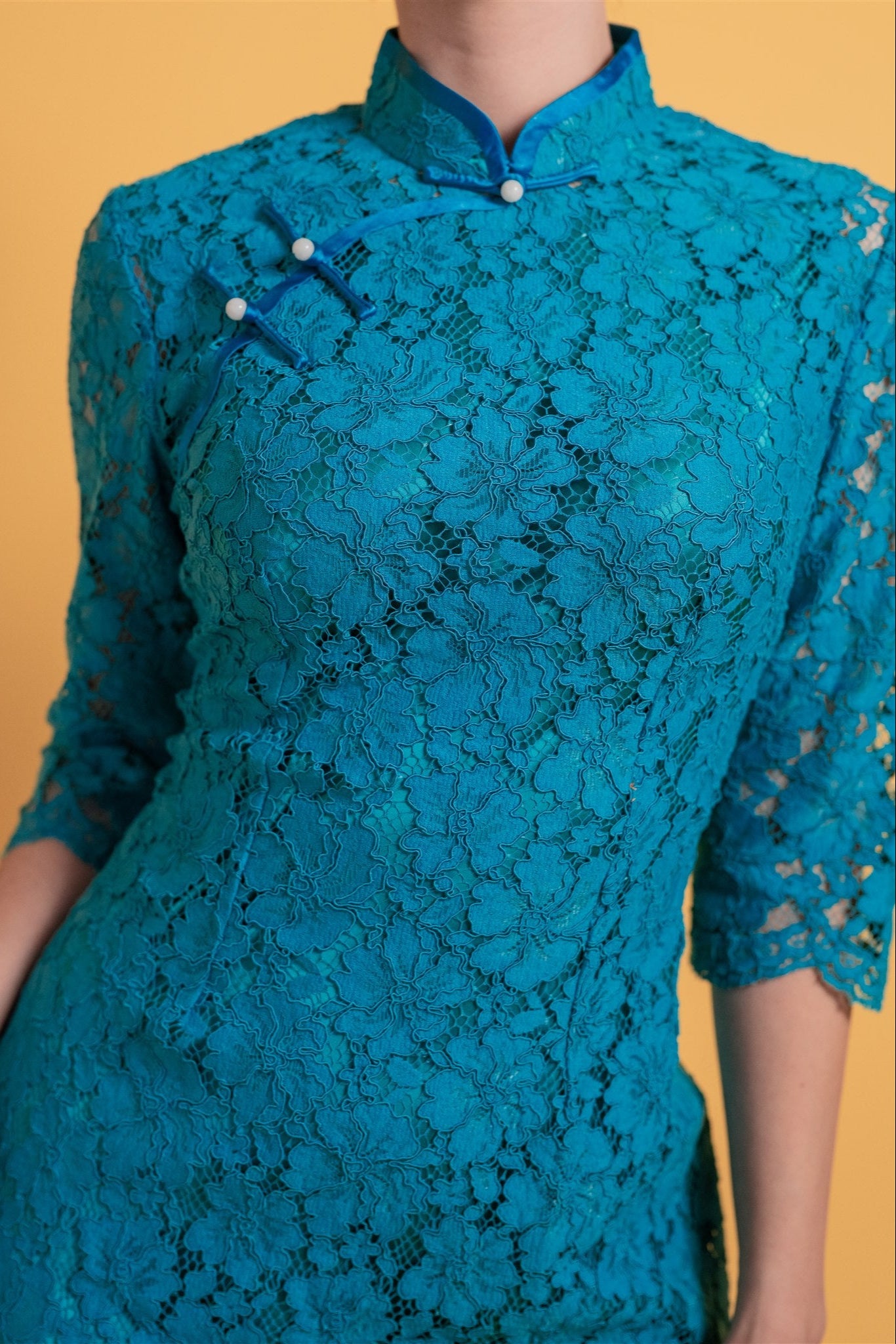 Close-up of teal blue floral lace on cheongsam with matching silk lining

