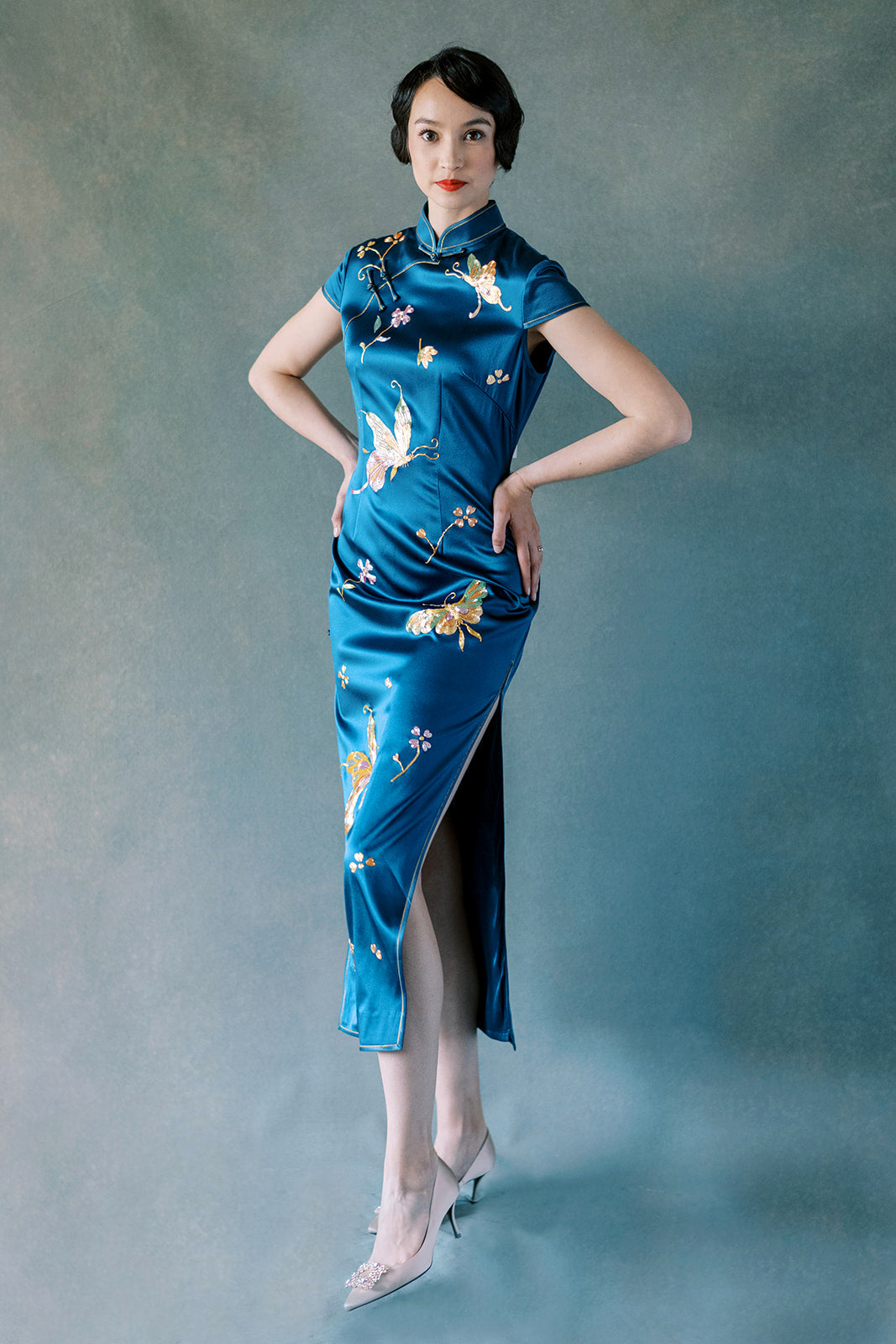 Front view of teal silk Cheongsam dress with peony and butterfly embroidery.