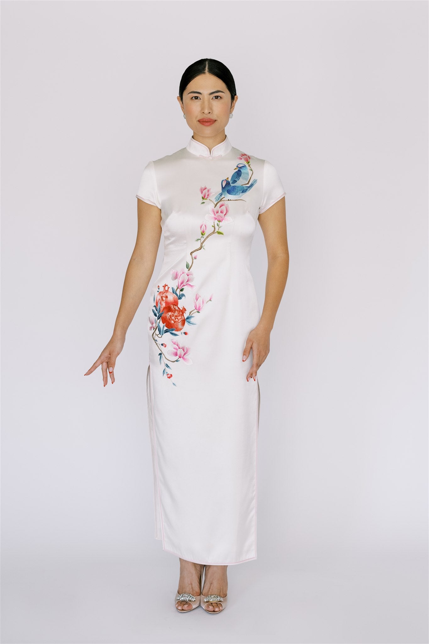 A woman wearing white Qipao with bird and magnolia flower embroidery