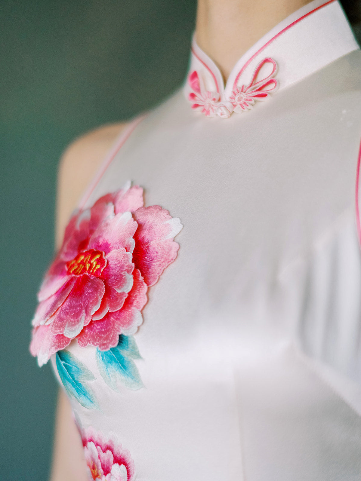 Close-up of 3-d hand embroidered pink peony on white Qipao