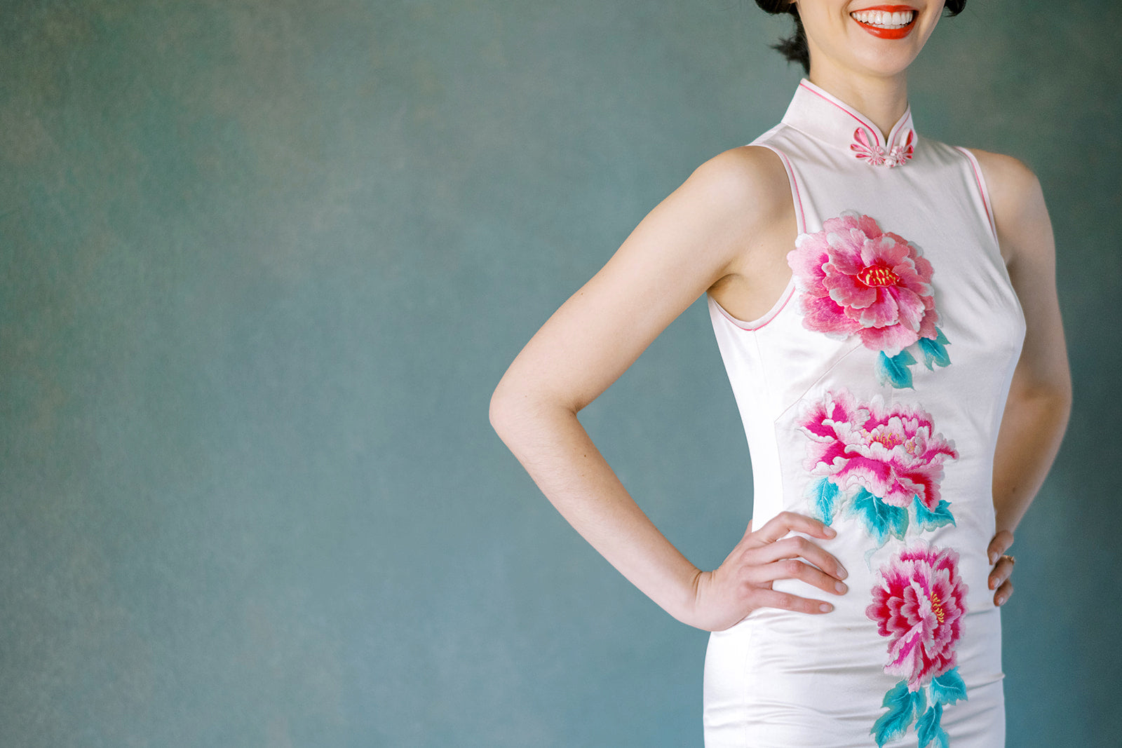 Close-up of 3D pink peony embroidery and hand-finished pink trim on Qipao