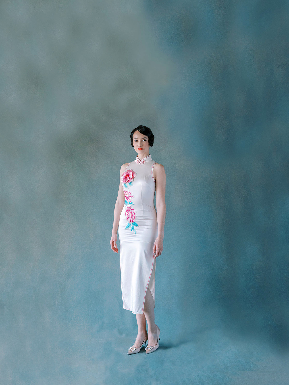 Front view of white silk halter Qipao dress with 3D embroidered peony motif.
