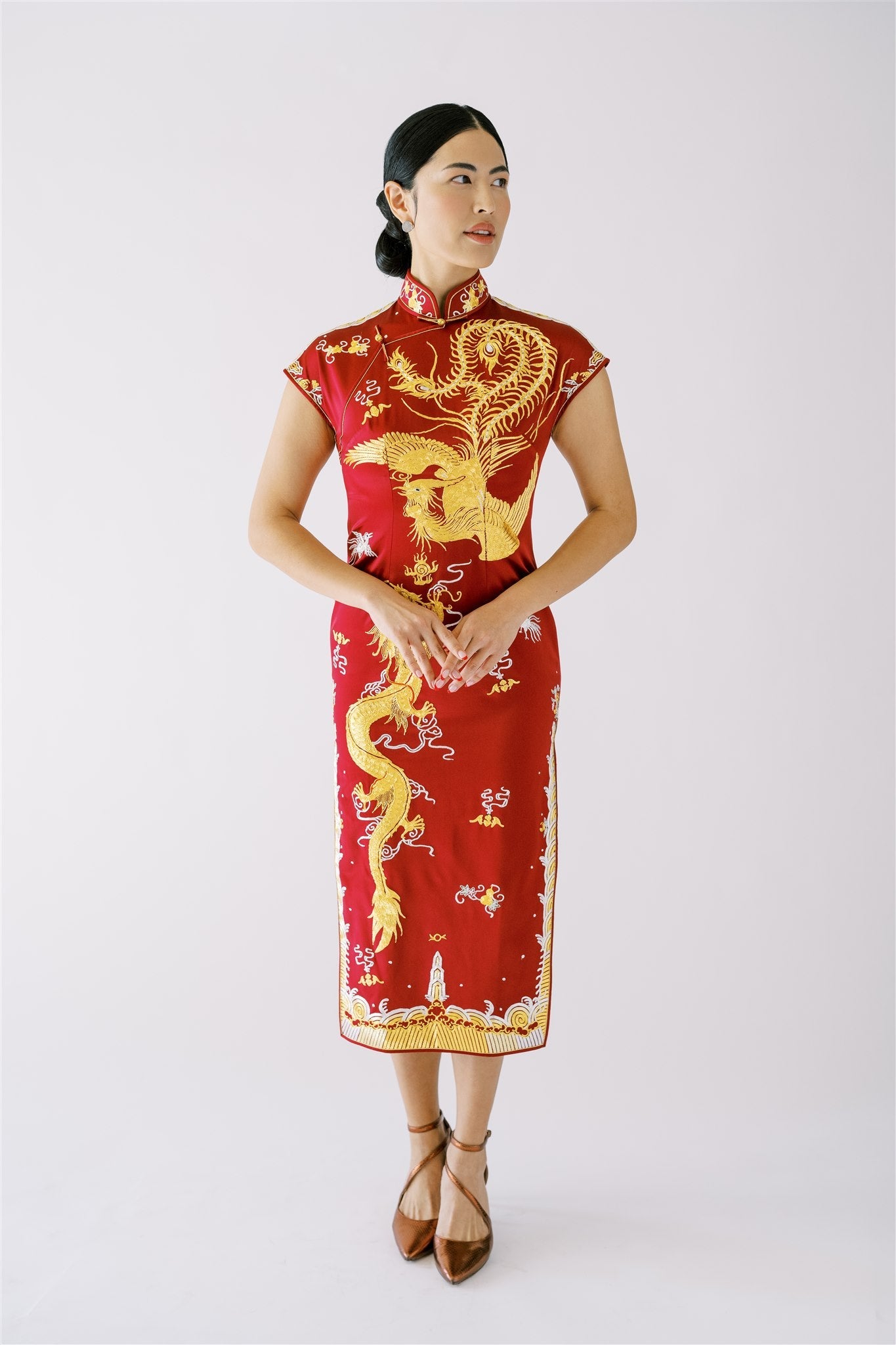  A woman wearing wine red Qipao dress for wedding with gold dragon and phoenix embroideries