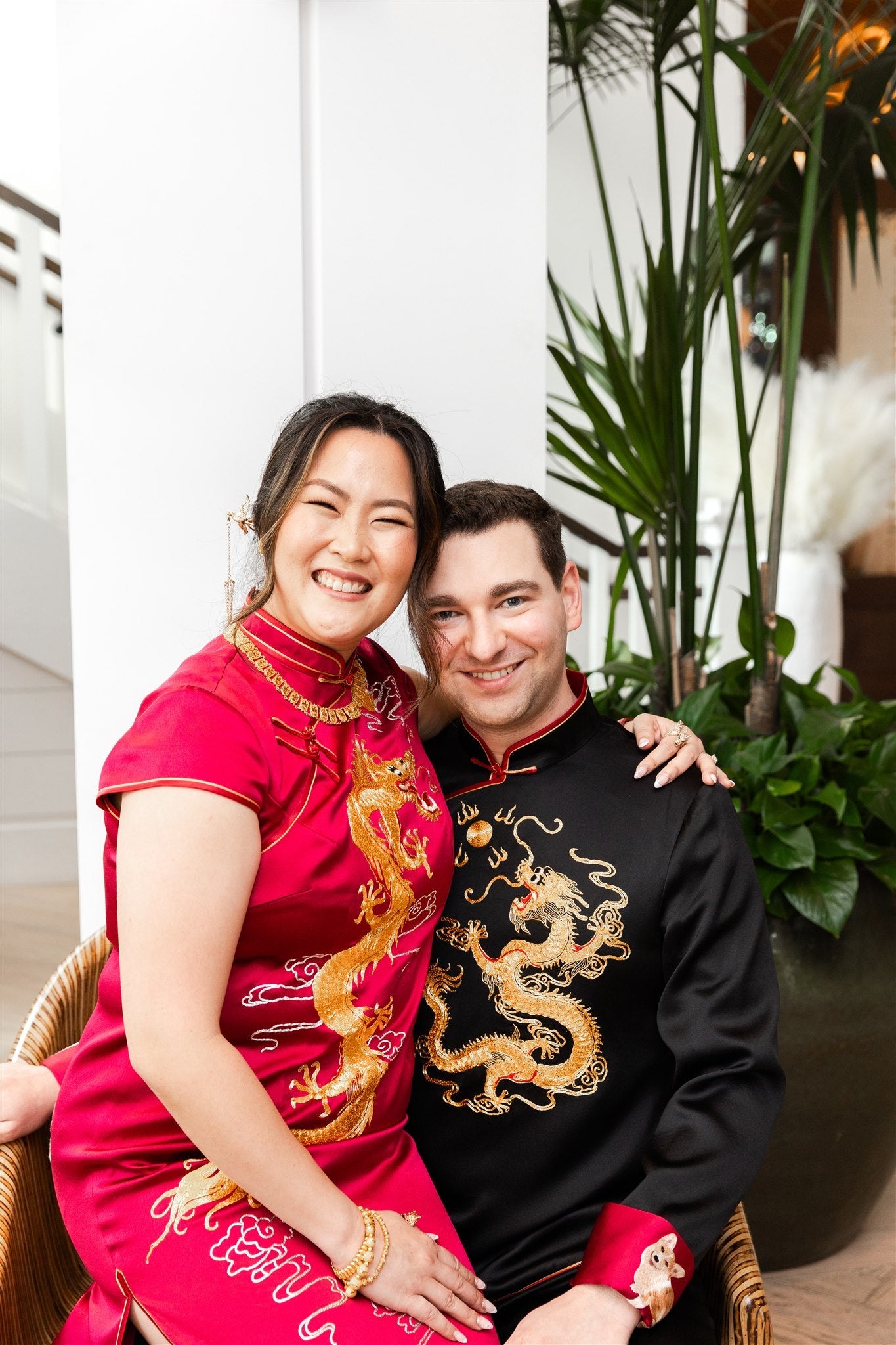 A bride wearing Qipao wedding dress in wine red and a groom is wearing black silk Chinese suit