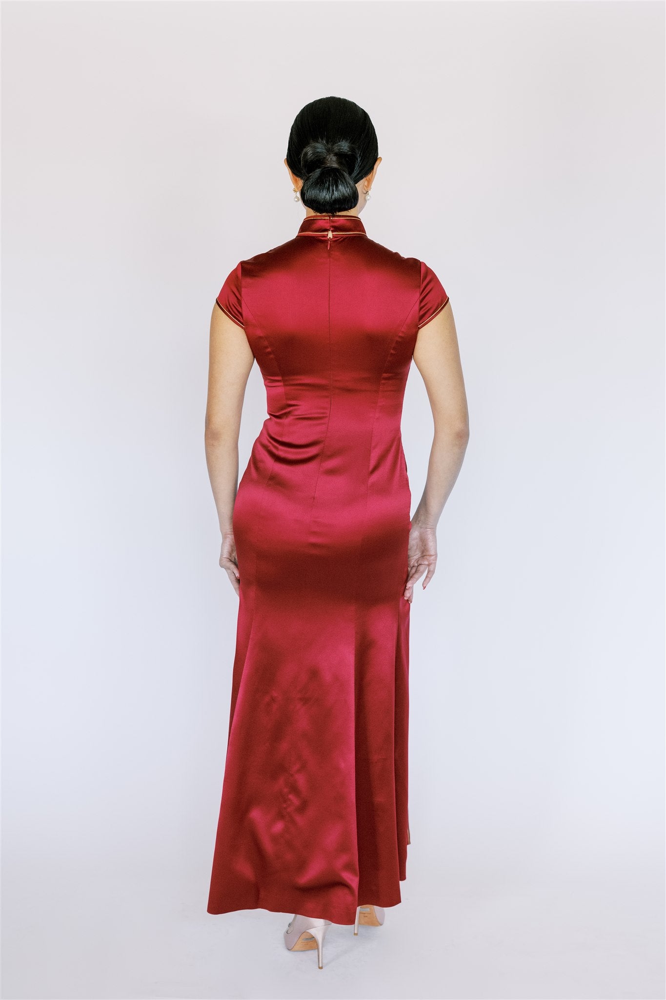 A woman wearing a mermaid wine red silk Cheongsam