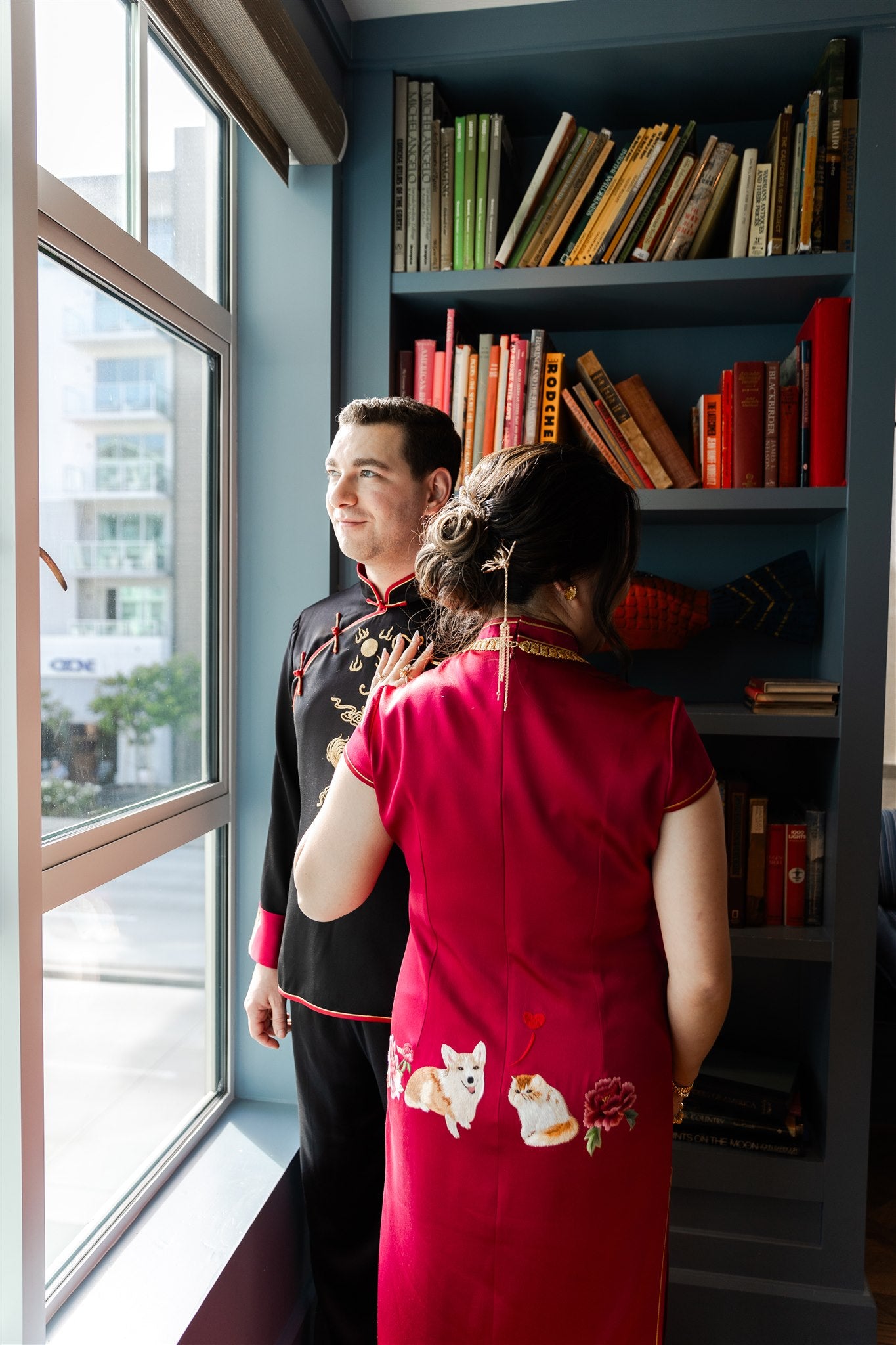 A bride wearing a wine red silk Chinese Wedding Dress with her dog and cat embroidered on the back